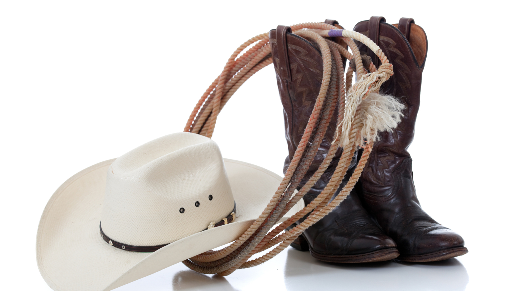 A white cowboy hat, brown leather boots and lariat on a white background