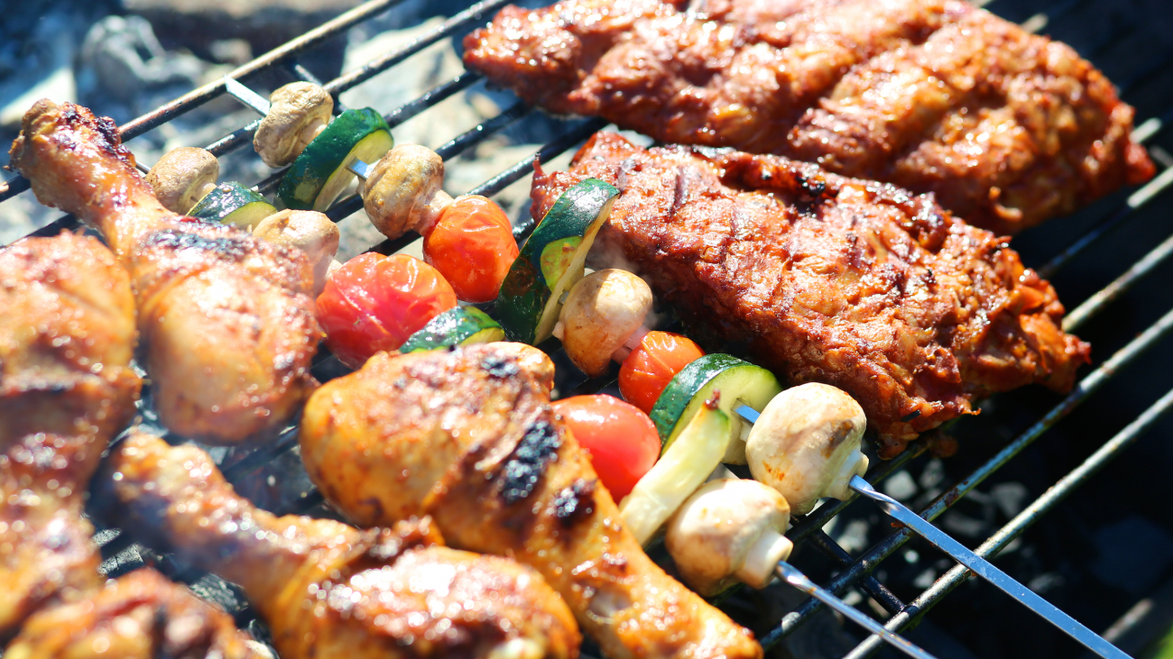 Assorted meat and vegetables on barbecue grill cooked for summer family dinner